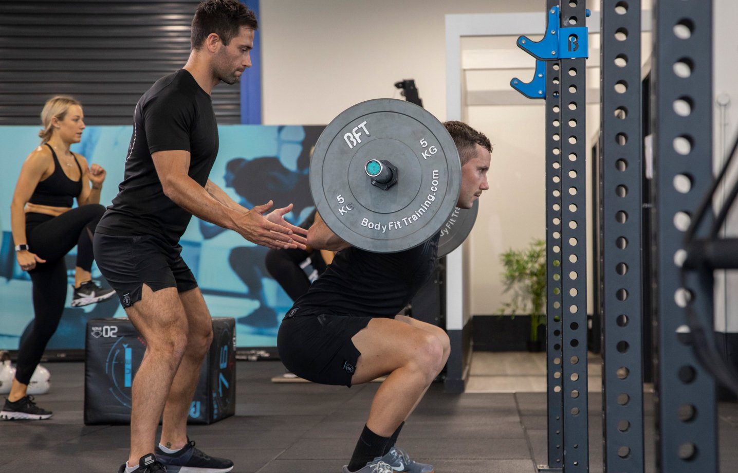 BFT instructor guiding person squatting